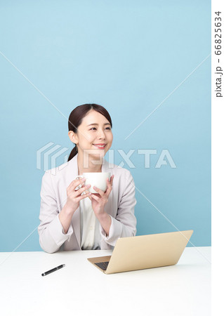 パソコンで仕事中お茶している女性 パソコンで仕事中お茶している女性 66825634