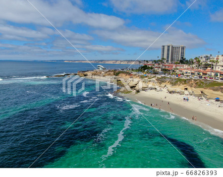 Beachgoers enjoying a beautiful sunny afternoon at La Jolla Cove 66826393