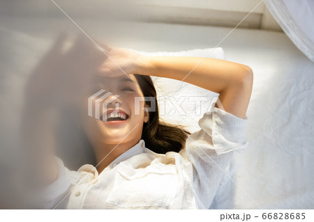 ベッドに寝転ぶ若い女性 ベッドに寝転ぶ若い女性 66828685
