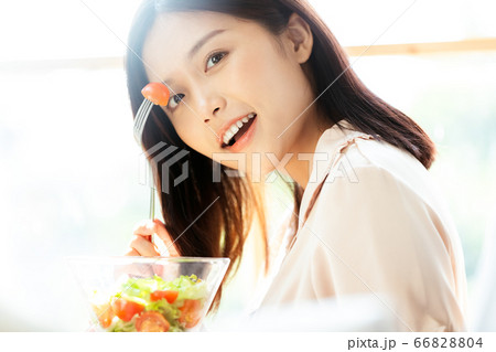 朝食をとるパジャマ姿の女性 66828804