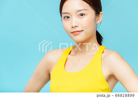 スポーツウェアを着た青背景の女性ポートレート 66828899