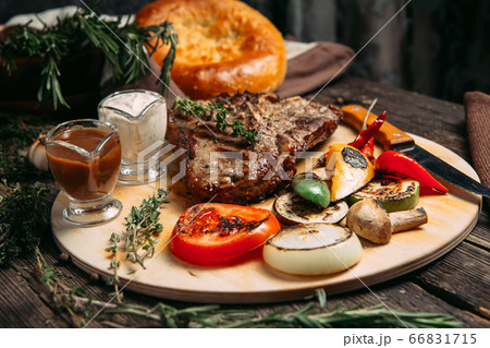 Juicy beef steak with grilled vegetables on board Juicy beef steak with grilled vegetables on board 66831715