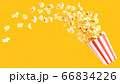 popcorn in classic bucket red and white splashing out of the box 66834226