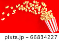 popcorn in classic bucket red and white splashing out of the box 66834227
