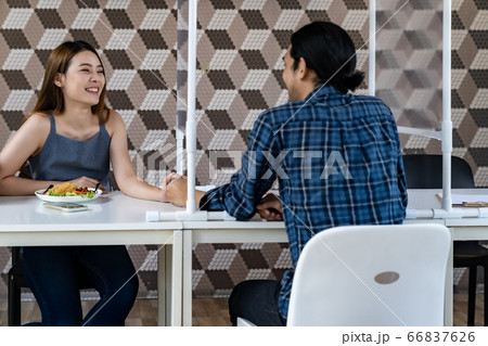 Asian couple eating out at new normal restaurant Asian couple eating out at new normal restaurant 66837626