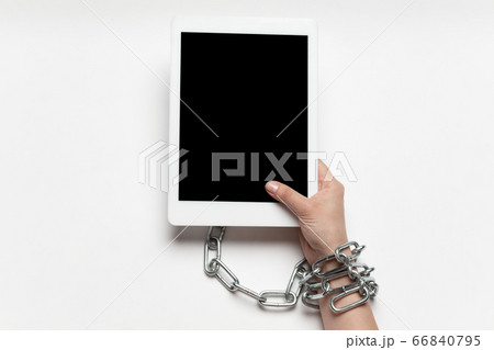 Close up of human hand using tablet with blank black screen. Tied with chain, addiction Close up of human hand using tablet with blank black screen. Tied with chain, addiction 66840795