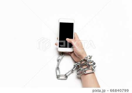 Close up of human hand using smartphone with blank black screen. Tied with chain, addiction Close up of human hand using smartphone with blank black screen. Tied with chain, addiction 66840799