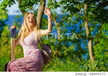Girl with guitar outdoor on nature Girl with guitar outdoor on nature 66844177