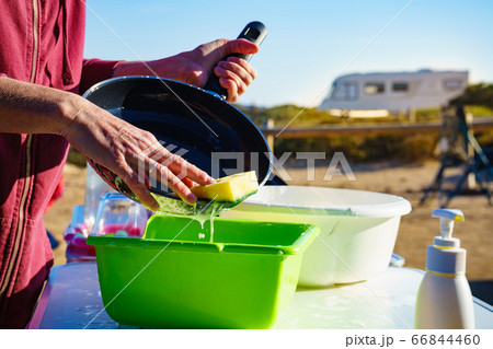 Woman washing dishes in bowl, capming outdoor Woman washing dishes in bowl, capming outdoor 66844460