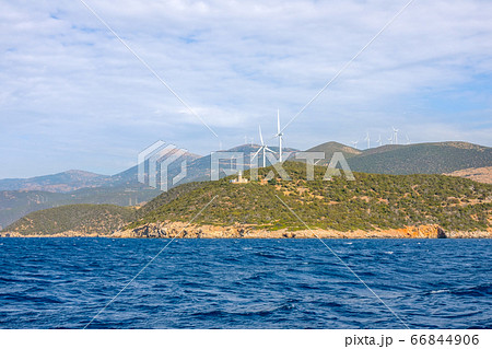 Lighthouse on a Hilly Shore and Wind Farms 66844906