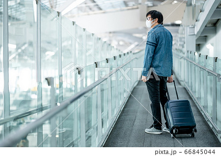 Asian man tourist wearing mask in airport terminal Asian man tourist wearing mask in airport terminal 66845044