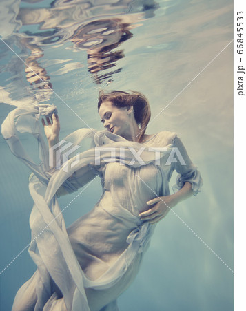 Portrait of a girl in a blue dress floating underwater 66845533