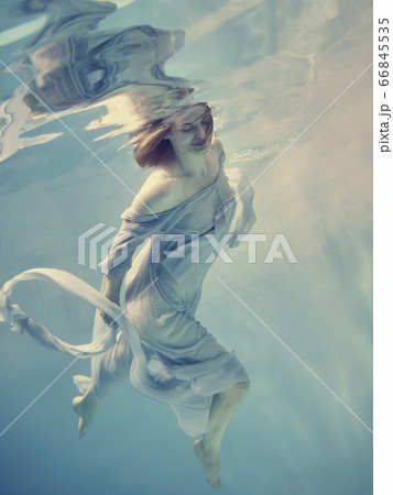 Portrait of a girl in a blue dress floating underwater 66845535