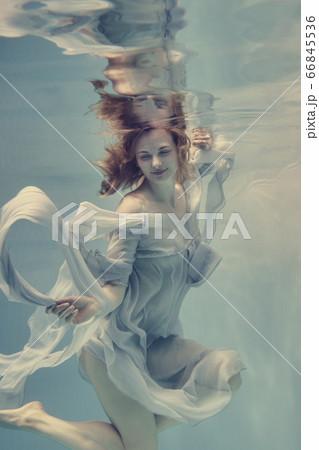 Portrait of a girl in a blue dress floating underwater Portrait of a girl in a blue dress floating underwater 66845536