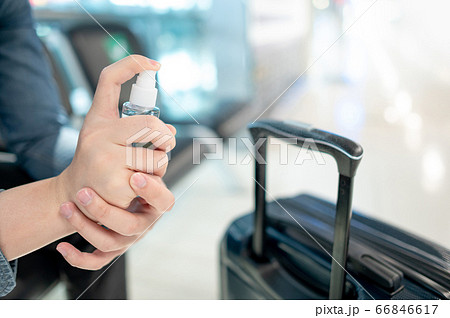 Cleaning suitcase handle with sanitizer spray 66846617