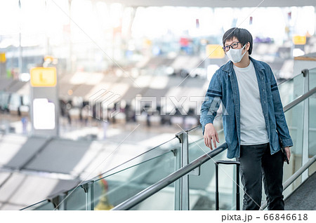 Asian man tourist wearing mask in airport terminal Asian man tourist wearing mask in airport terminal 66846618
