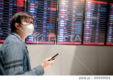 Asian man tourist wearing mask in airport terminal Asian man tourist wearing mask in airport terminal 66846668