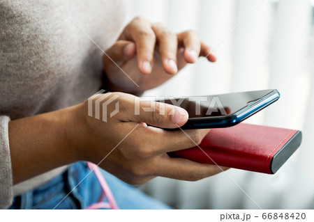 young woman's hand is playing with a smartphone 66848420