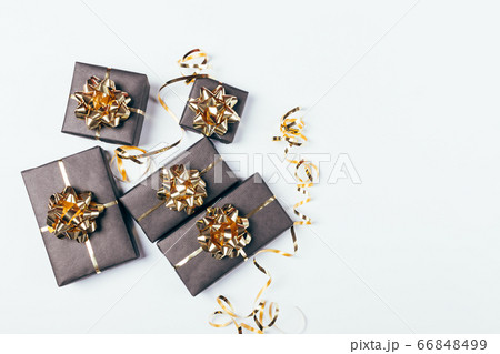 Festive black gift boxes with golden bows and 66848499