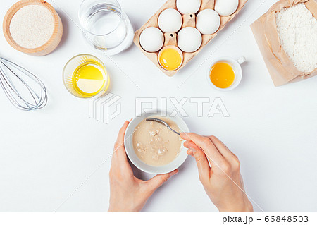 Top view female hands mix yeast with water Top view female hands mix yeast with water 66848503