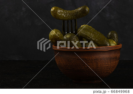 Gherkins and sauerkraut in a clay bowl on a dark Gherkins and sauerkraut in a clay bowl on a dark 66849968