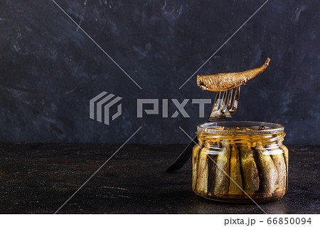 Glass open jar of sprots and fish on a fork Glass open jar of sprots and fish on a fork 66850094