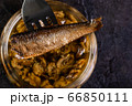 Sprat on a fork over a glass jar 66850111