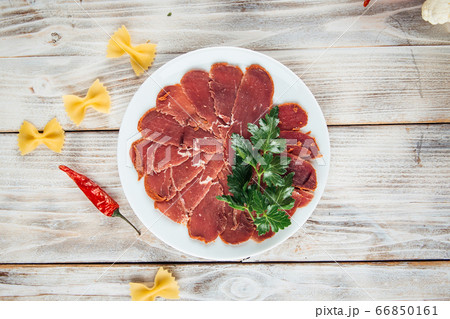 Top view on sliced basturma slices with herbs Top view on sliced basturma slices with herbs 66850161