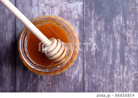 Top view of fresh honey in a jar on wooden table. 66850854