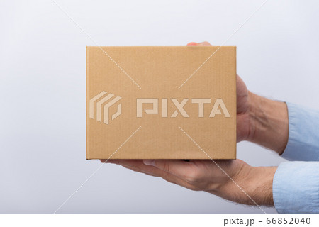 Square cardboard box in male hands. Delivery of Square cardboard box in male hands. Delivery of 66852040