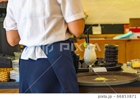 Waitress serving beverage at bar counter in coffee shop  66853871