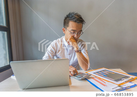Wearing glasses financial accountant using calculator, analyzing graph document 66853895