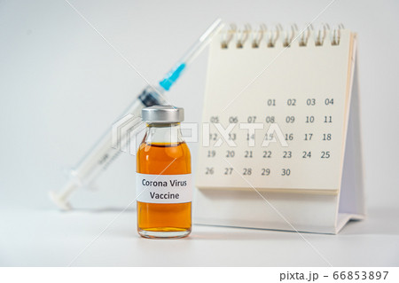 Coronavirus vaccine bottle and syringe injection next to 2020 calendar  66853897