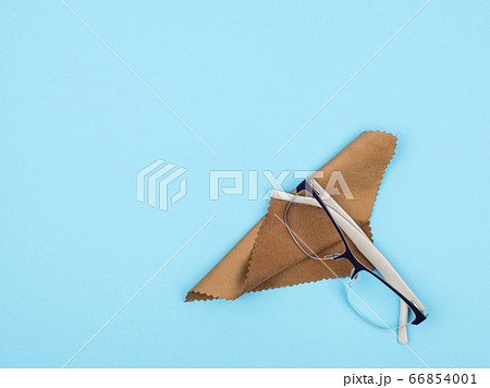 Glasses and a cloth for wiping lenses on a blue background. Glasses and a cloth for wiping lenses on a blue background. 66854001
