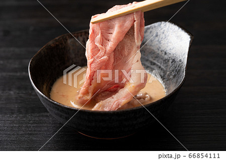 しゃぶしゃぶを胡麻だれに浸ける　国産和牛肩ロース肉 66854111