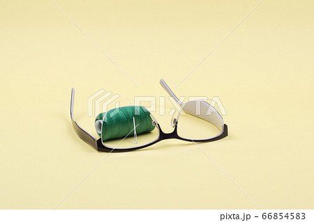 In the inverted glasses see the thread with a needle on a yellow background. 66854583