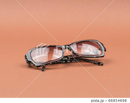 Tinted glasses on a brown background. The view from the top. Tinted glasses on a brown background. The view from the top. 66854698