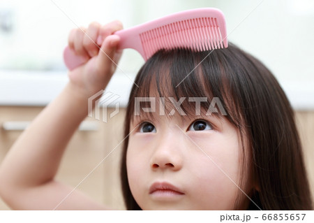 くしを使ってブラッシングするオシャレに目覚めた娘 66855657