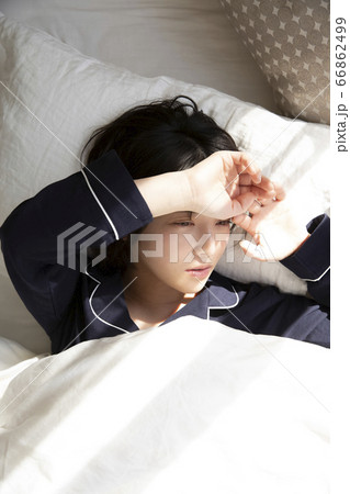 ベットで寝ている若い女性 66862499