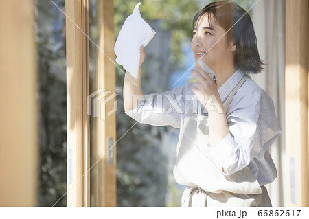 窓を掃除する若い女性 66862617