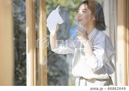 窓を掃除する若い女性 66862649