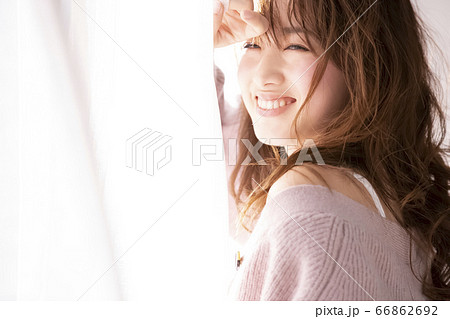 部屋でくつろぐロングヘアの若い女性 66862692