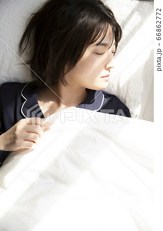 ベットで寝ている若い女性の写真素材