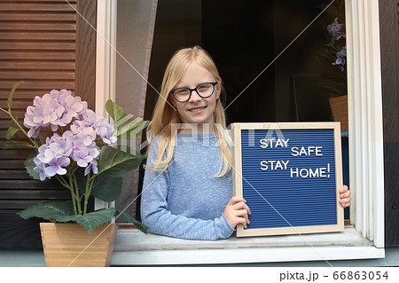 Stay home quarantine coronavirus pandemic prevention. Beautiful girl stays near the open window Stay home quarantine coronavirus pandemic prevention. Beautiful girl stays near the open window 66863054