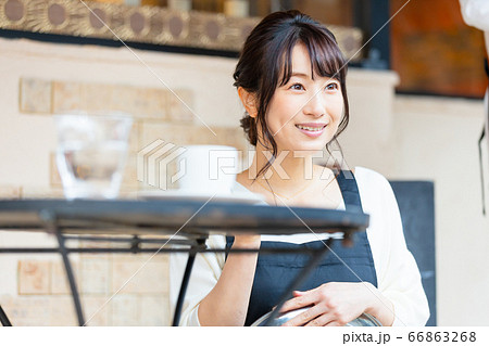 屋外席で接客中の若い飲食店店員女性 66863268