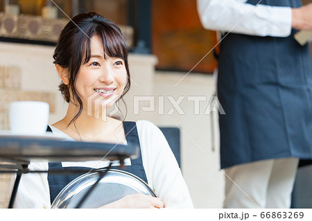 屋外席で接客中の若い飲食店店員女性 屋外席で接客中の若い飲食店店員女性 66863269