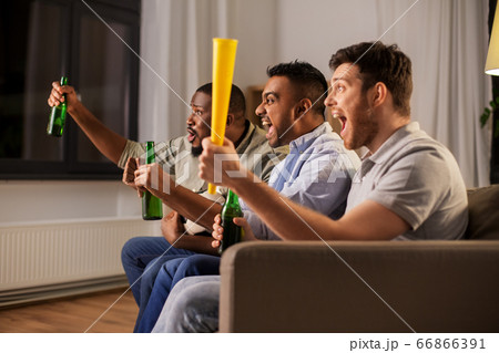 friends or soccer fans with ball and beer at home 66866391