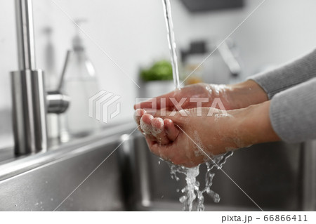 woman washing hands with liquid soap in kitchen 66866411