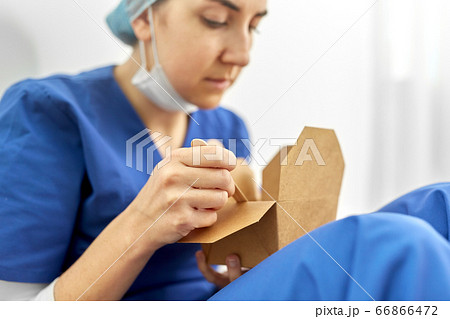 sad doctor or nurse eating takeaway food from box sad doctor or nurse eating takeaway food from box 66866472