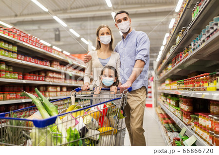 family with shopping cart in masks at supermarket 66866720